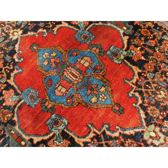 Rust medallion atop blue field decorated with Herati pattern. Rust border with stylized turtle motif. Early 1900s. hand...