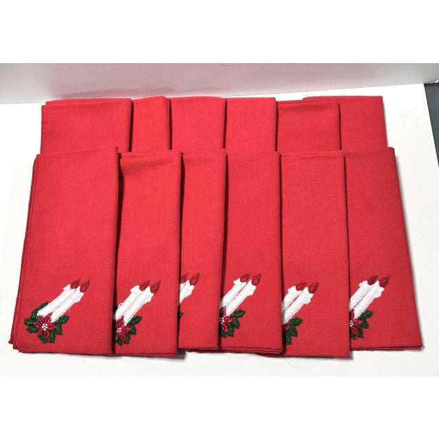 Set of 12 vintage red Christmas dinner napkins embroidered with white candles, poinsettias and green foliage. The...
