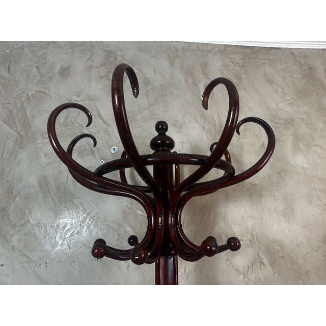 An elegant coat rack, dating from the 1920s, crafted from bent beechwood stained in a deep mahogany hue. This iconic piece...