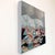 Languishing presents a serene yet haunting scene, featuring a ghostly white horse resting amidst a chaotic tapestry of...