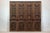 This vintage Chinese four-panel folding screen features a rich dark red-brown ground with hand-painted decorative panels...