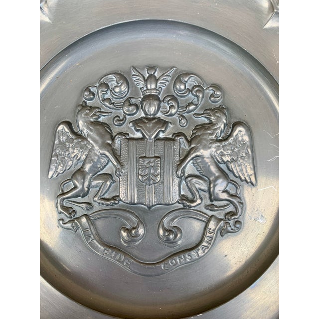 A beautiful pewter wall plate featuring a heraldic coat of arms with a knight Germany, Mid-20th Century Measures: 9"W x...