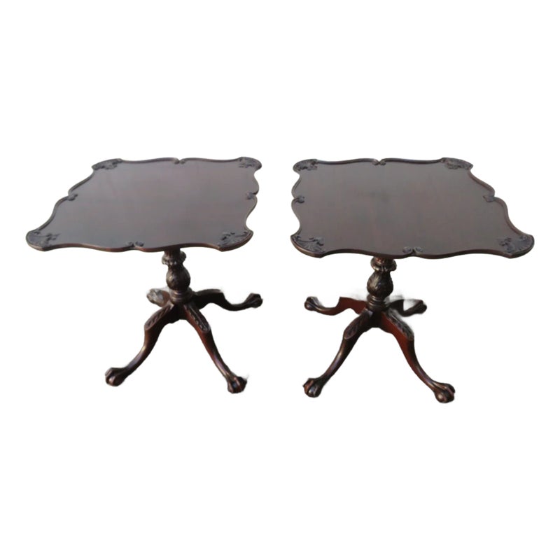 Two dark brown tables with ornate legs and scalloped tops