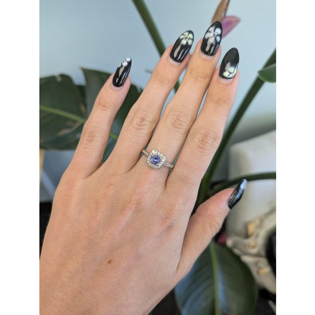 A vivid AA-grade tanzanite glows in violet-blue at the centre of this solid 14K yellow gold estate ring, framed by twenty-...