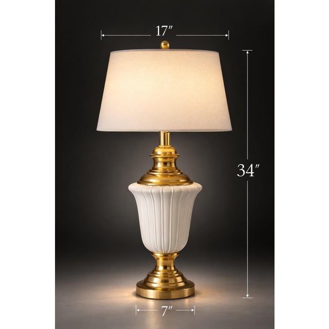A striking tall Hollywood Regency table lamp featuring a sculptural milk glass urn body with polished brass hardware and...