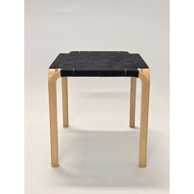 Artek's model Y61 stool, birch with black saddle belts. Designed by Alvar Aalto. In very good used condition. Airy design...