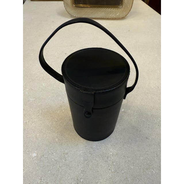 Refined vintage travel bar set, produced in Germany circa the 1970s, featuring a cylindrical black leather–clad case with...