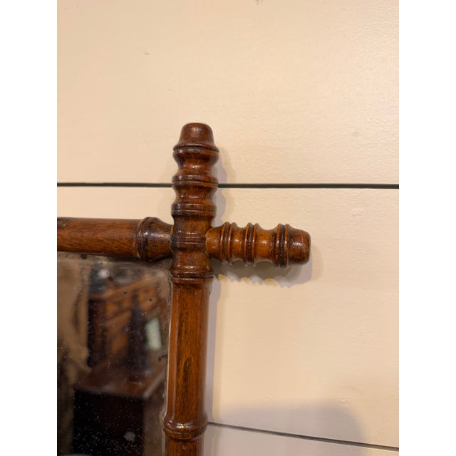 This is a French antique faux-bamboo wall mirror with a hand-carved wood frame. The frame is wood that has been shaped and...