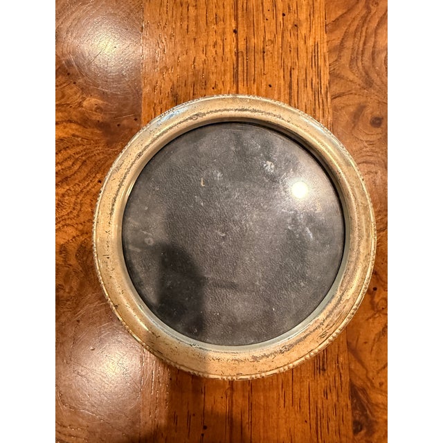 Charming pair of vintage round picture frames featuring a classic brass-tone finish and velvet-covered easel backs. Their...