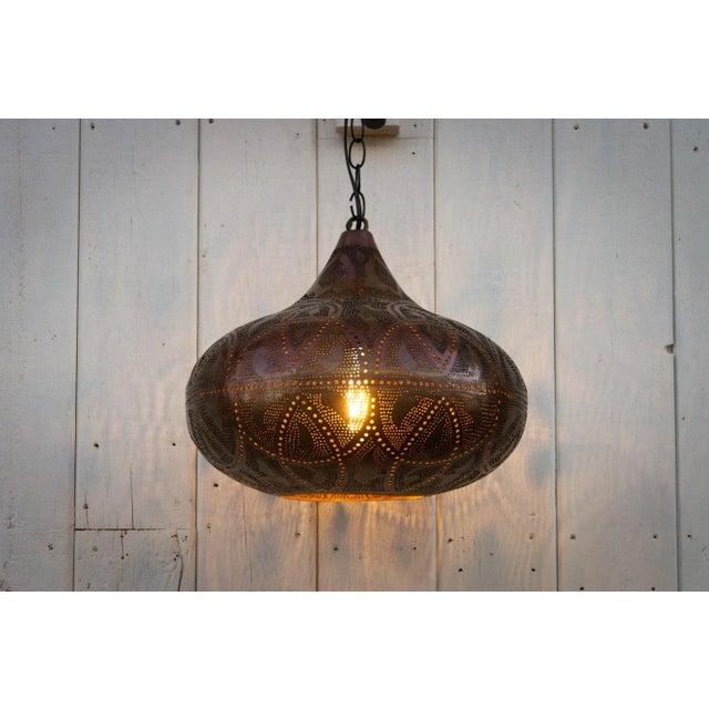 A delicately perforated Moorish pendant lantern. This pendant features pierced foliate see-through work which is all done...