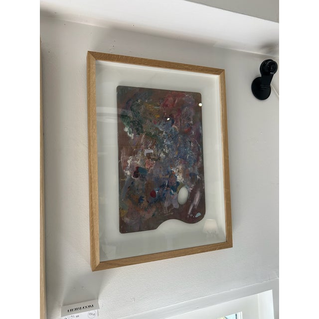 Expressive abstract paint palette composition featuring layered magentas, blues, and earthy tones with dimensional impasto...