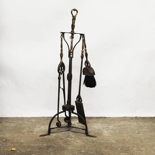 A decorative Arts and Crafts fire companion set. This piece is attributed to the mentioned designer/maker. It has no...