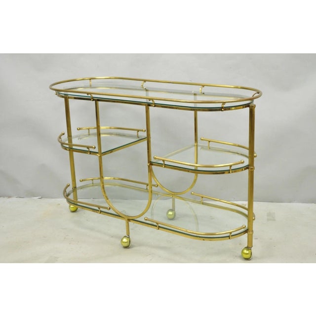 Vintage Mid Century Modern Brass 3 Tier Oval Frame Rolling Bar Cart Serving Table with 4 Glass Shelves. Circa Late 20th...