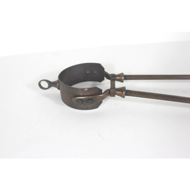 Antique Victorian Brass and copper tone fire or coal tongs. These have claw type tips, a loop at the top for hanging and a...