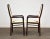 A pair of mid century modern rosewood color dining chairs with off white fabric made by Boltinge. Seat height is 17”....