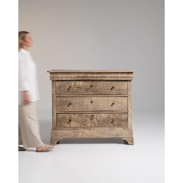 Whitewashed oak commode in Whitewashed Oak. Its whitewashed oak finish sets off three drawers, brass ring pulls, gently...