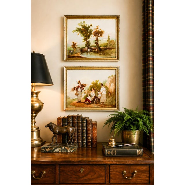 A captivating pair of antique 19th-century hand-painted porcelain plaques, each depicting an idyllic pastoral scene with...