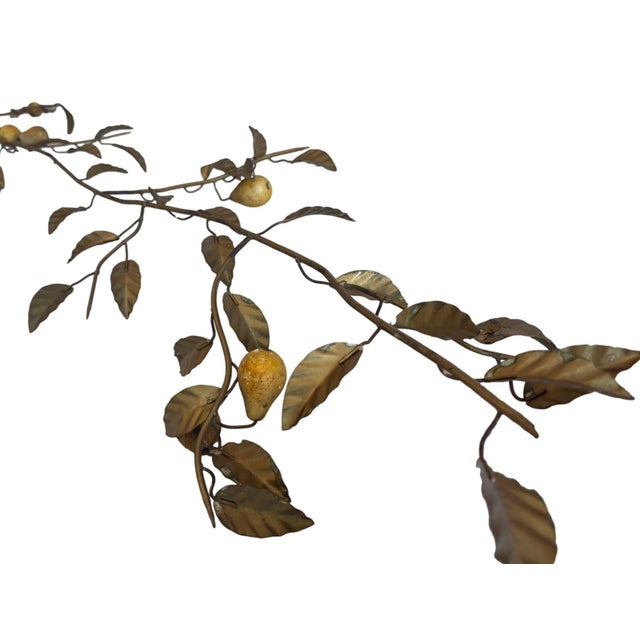 This gold-painted tole branch features delicate, hand-crafted metal leaves with speckled yellow pears. The intricate...