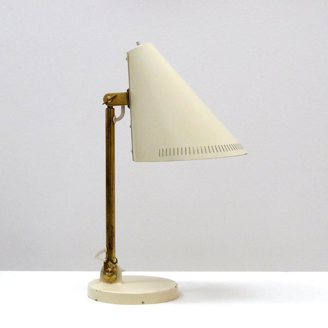 Wonderful early desk lamp model 5305 by Paavo Tynell for Taito, Finland, with a large articulate crème colored enameled...