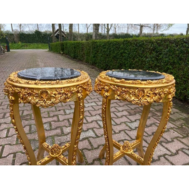 This elegant pair of circa 1980 French Louis XVI–style side tables combines finely carved gilt beechwood with polished...