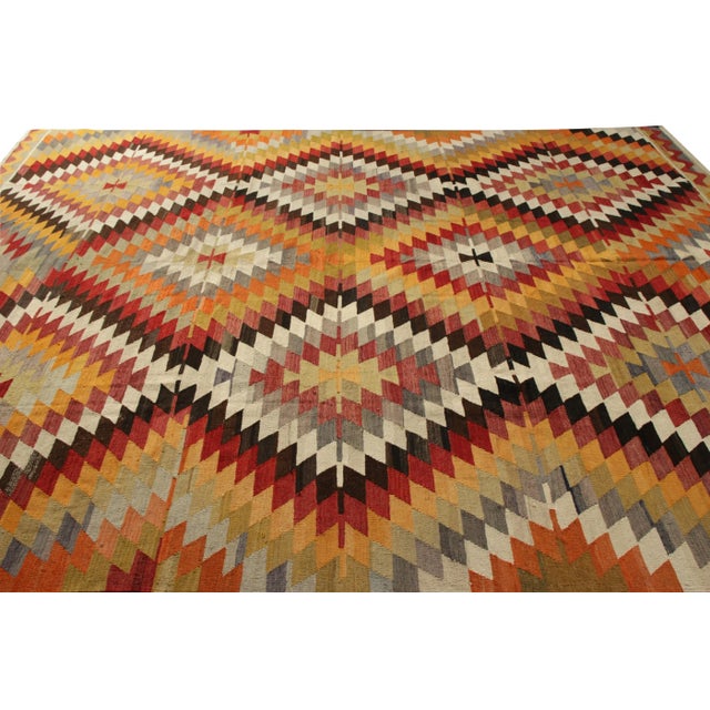 Handwoven in wool originating from Turkey circa 1950-1960, this item is a vintage Kilim rug connoting a midcentury Turkish...