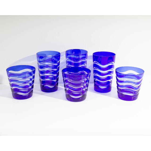 A set of cut to clear glasses. Included in this set are three taller glasses and three tumblers. Each glass has a blue cut...