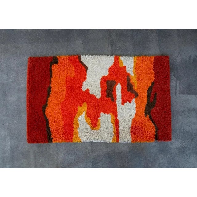 A beautiful, vibrant Rya Rug in yellow, orange, red, brown and white. It features long threads, creating a fluffy feeling...