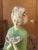 Geisha Figurine holding flower petals. Faux Jade on Ebony Base. Detailed Geisha Robe features two different shades of green.