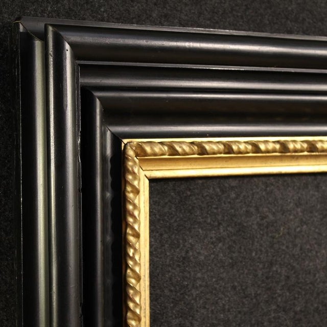 Mid-20th-century Italian frame. Beautifully ebonized and gilded wood cabinet with attractive lines and furnishings. The...