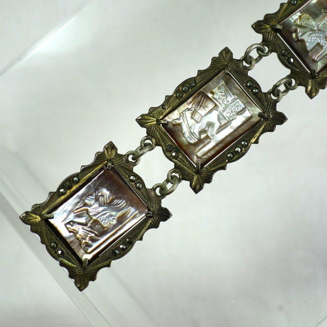 Vintage Art Deco 800 silver, mother-of-pearl shell cameo, and marcasite bracelet, 1930s. Intricately carved frames...