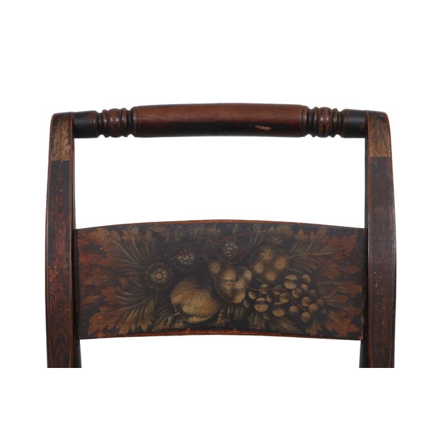 An American classical New England style stenciled rocking chair made in the manner of Lambert Hitchcock. The chair is...