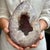 A striking egg-shaped amethyst quartz geode showcasing the timeless beauty of natural crystal formations. With its...