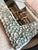 Handmade mirror featuring a beautifully textured frame composed of natural cat’s eye shells (turbo snail operculum)...
