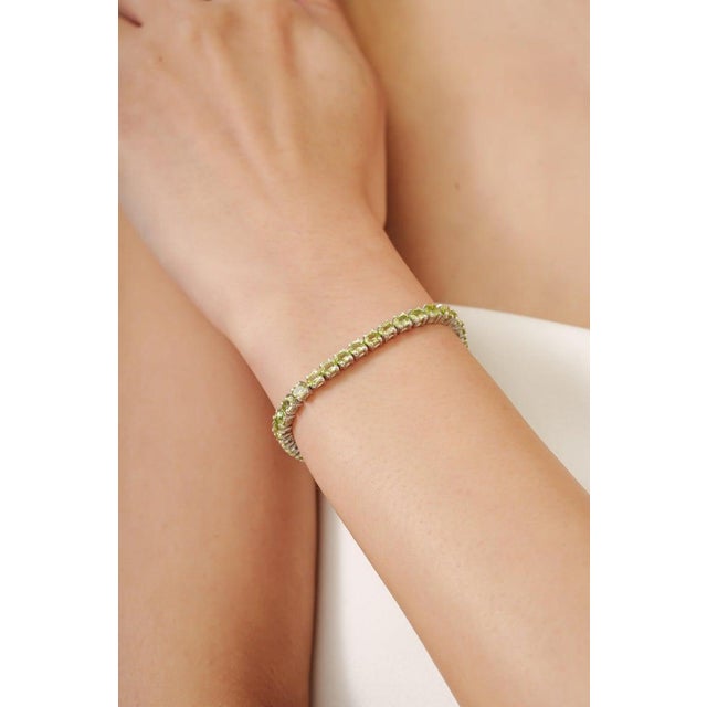 This Elegant bracelet is crafted in premium 925 sterling silver and adorned with 46 natural oval cut peridot gemstones....