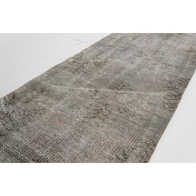 This is a vintage Turkish Oushak rug from the Mid 20th Century. The piece was hand-knotted.