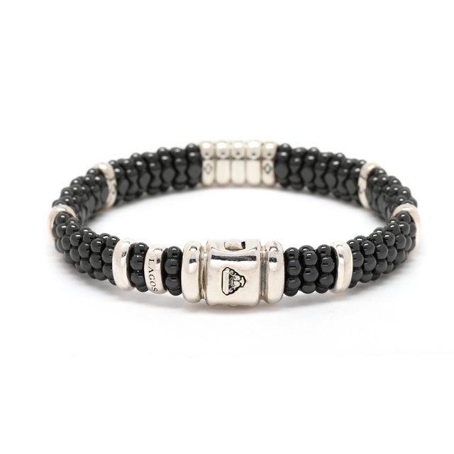 Stones: diamond round brilliant cut .28ctw GH color/SI1-2 clarity black ceramic beads Circumference: 6.5 in. Width: 3/8...