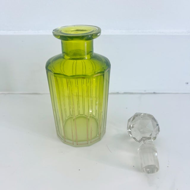 Antique perfume glass bottle with stopper. Gold tone details, cut glass stopper, ombre coloring from green to yellow to...