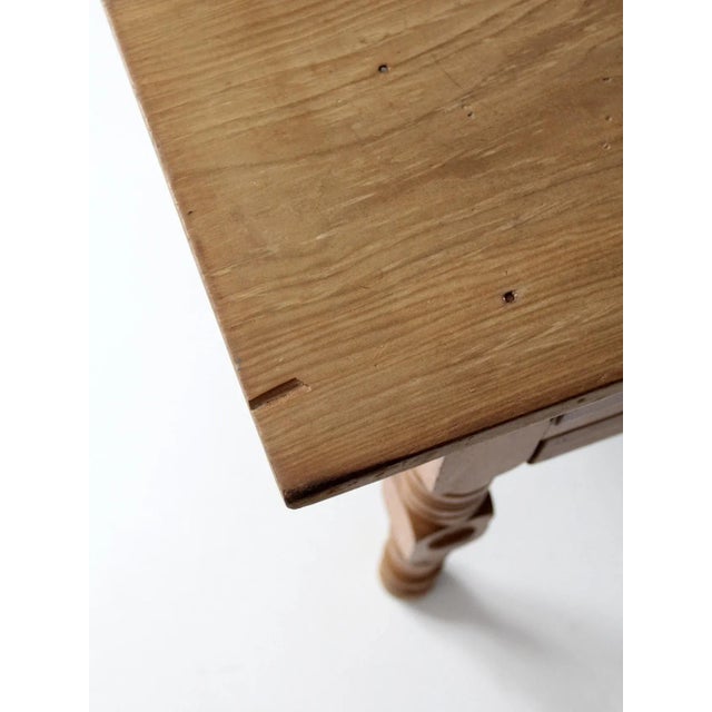 An antique baker’s table dating to circa 1900, often referred to as a “doughboy” or “possum belly” table. Crafted in warm,...