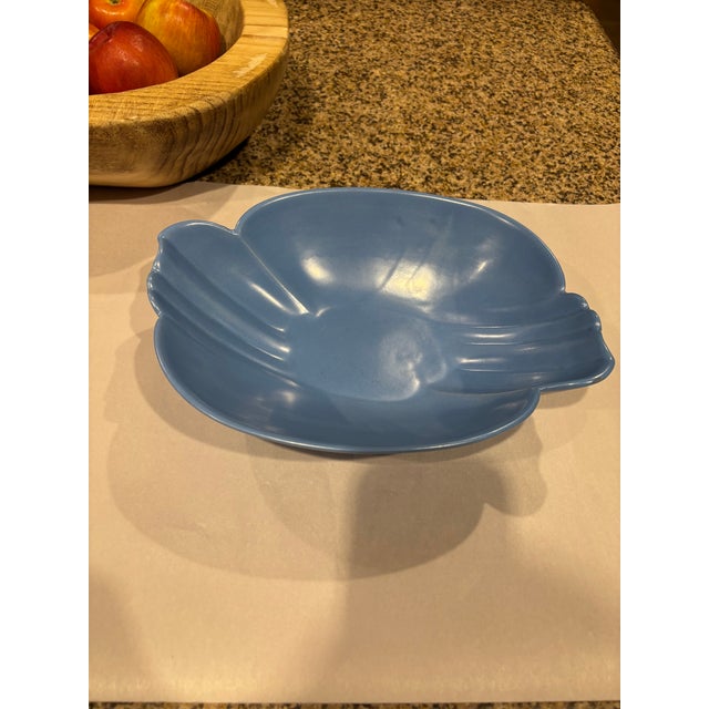 A beautiful mid-century modern Bauer Pottery bowl in a satin matte sky blue glaze, featuring a flowing folded-rim shell...