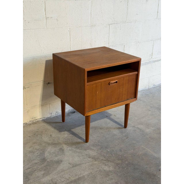 This exceptional vintage nightstand features an open upper shelf paired with a drop-down lower storage cabinet. Exhibiting...