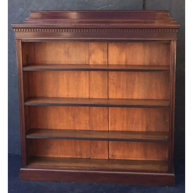 A fine English open-face bookcase of mahogany, with three adjustable shelves, featuring a moulded top and frieze with...