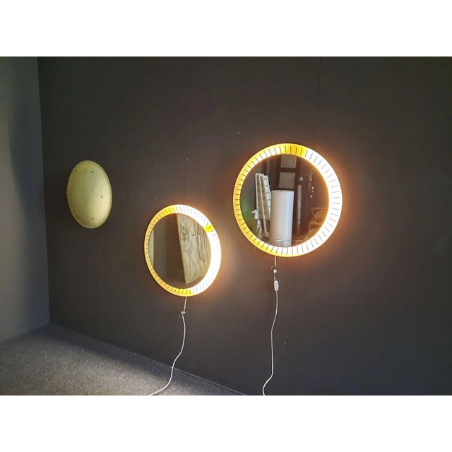 Great, rare wall lamp from the 1950s. The lamp has a round, functioning neon tube behind the mirror glass. with a diameter...