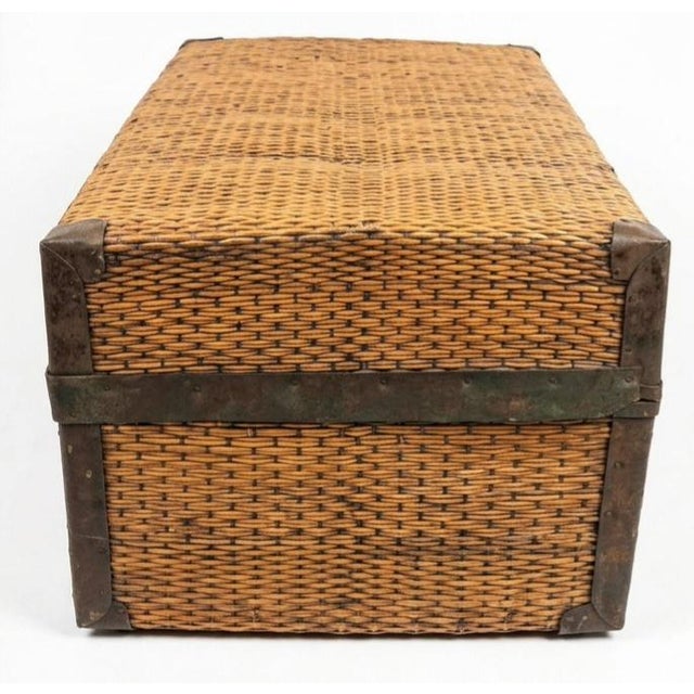 This specific piece is an antique hand-woven bamboo and wicker travel trunk (often referred to as an export suitcase or...