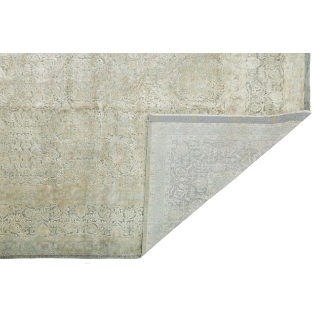 This contemporary hand-knotted rug showcases a stunning floral design with a vibrant color scheme. Crafted from high-...