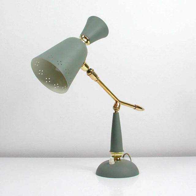 This vintage midcentury table lamp was manufactured in france in the 1950s. It is made of grey lacquered metal and has got...