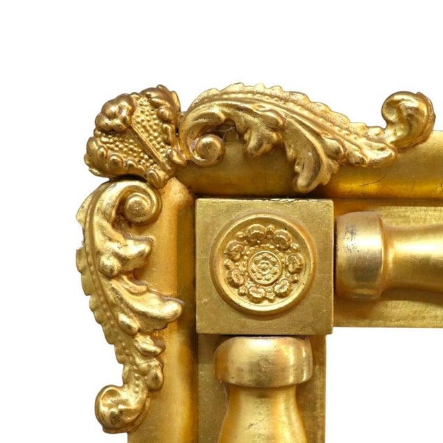 An antique Early American Empire style mirror, crafted from wood with a radiant gold gilt finish, dating to approximately...
