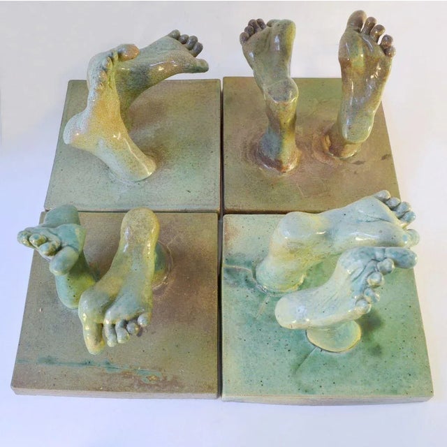 Bergos' tapestry of feet consists four ceramic tiles made into a relief with feet walking upwards from the tile squares,...