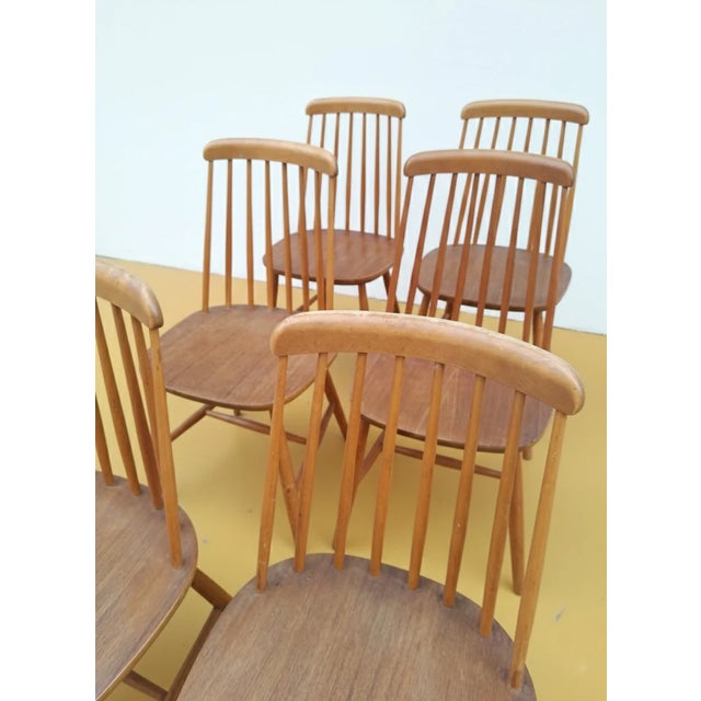 Four vintage Danish teak chairs from the 1950s with elegantly comfortable backrests, perfect for a refined and functional...