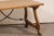 An Italian-style wooden trestle-leg table, with forged-iron stretcher, by high-end American furniture maker Michael...