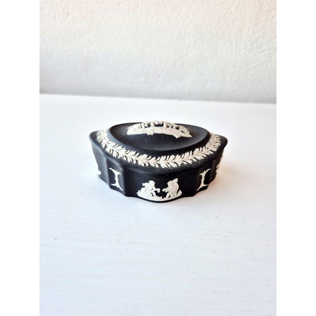 A refined black jasperware jewelry box (matte stoneware) with white slip decorations in relief, produced by the renowned...